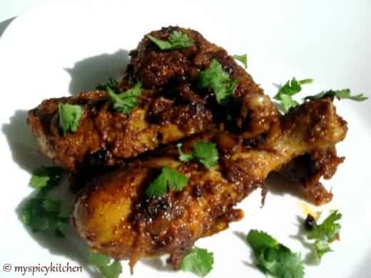 spicy kerala chicken fry and three drumsticks plated on a white plate.