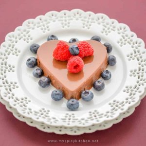 Heart shaped mocha panna cotta garnished with raspberries and blueberries