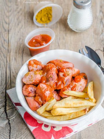Currywurst, German street food and national dish. Grilled pork sausage is served with curry flavored ketchup or tomato sauce.