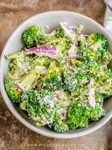 A bowl of roast broccoli salad with hemp seeds tossed in mayo sour cream dressing