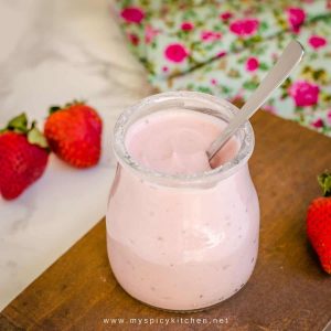 a jar of strawberry yogurt with a spoon