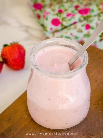 a jar of strawberry yogurt with a spoon