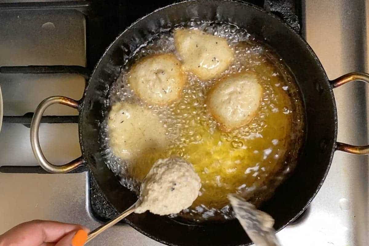 Dropping batter into oil for deep frying.
