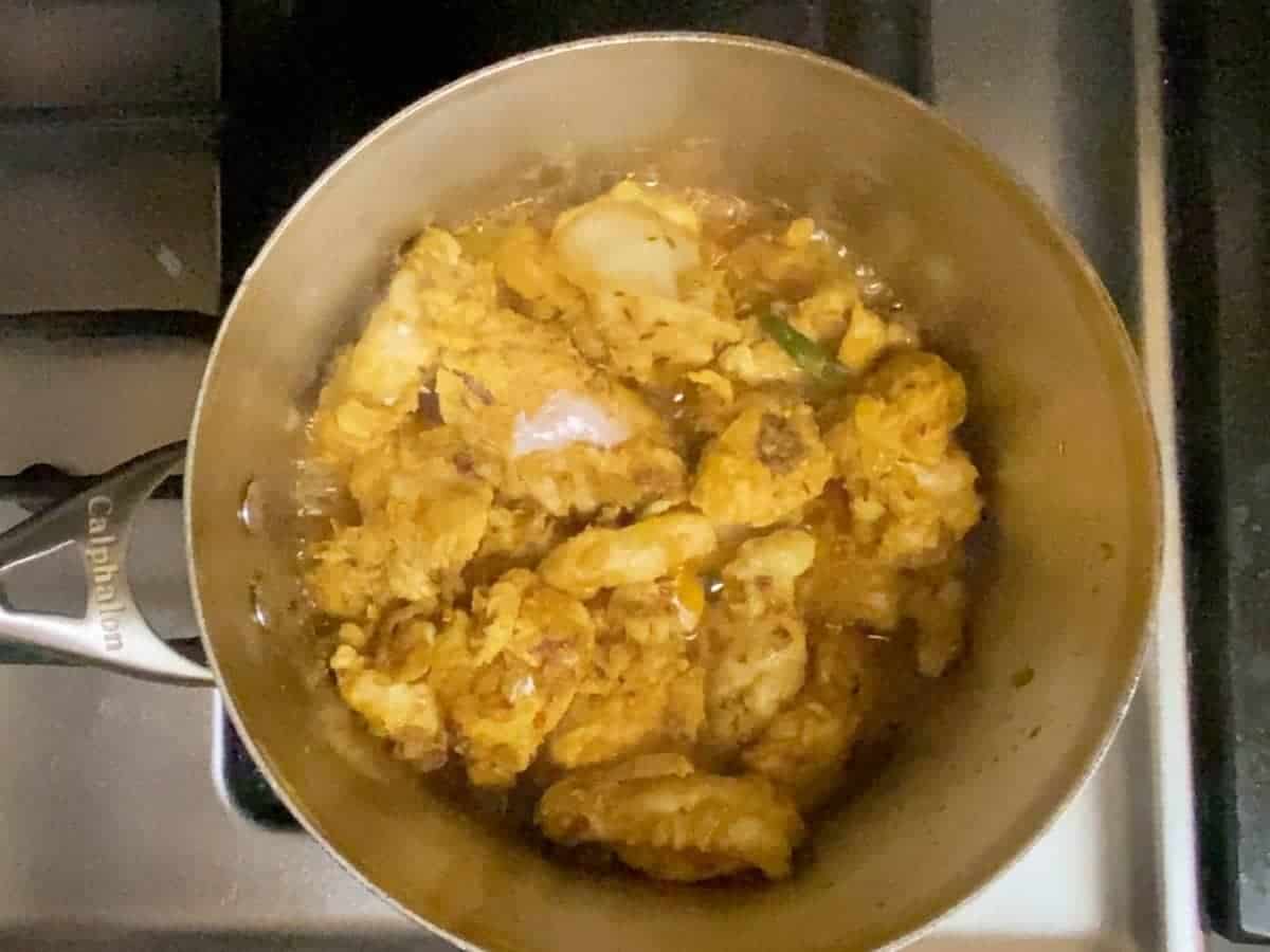 Semi cooked chicken in a saucepan.